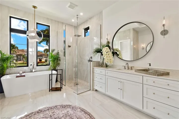 Bathroom with a freestanding tub, a stall shower, and vanity