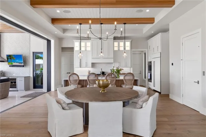 Dining room with a wood ceiling with exposed beams, light wood-style floors, beverage cooler, a chandelier, and recessed lighting