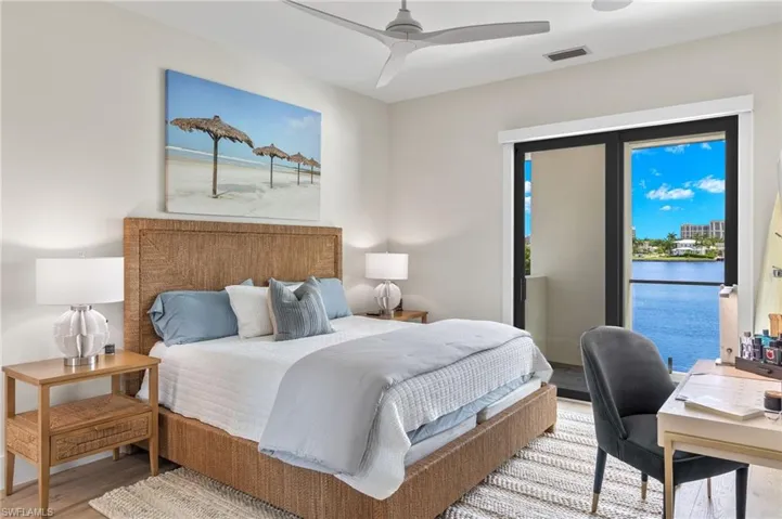 Bedroom with access to outside, wood finished floors, ceiling fan, and a water view