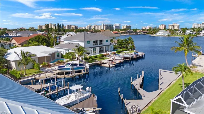 Water view featuring city skyline, boat lift, and a boat dock