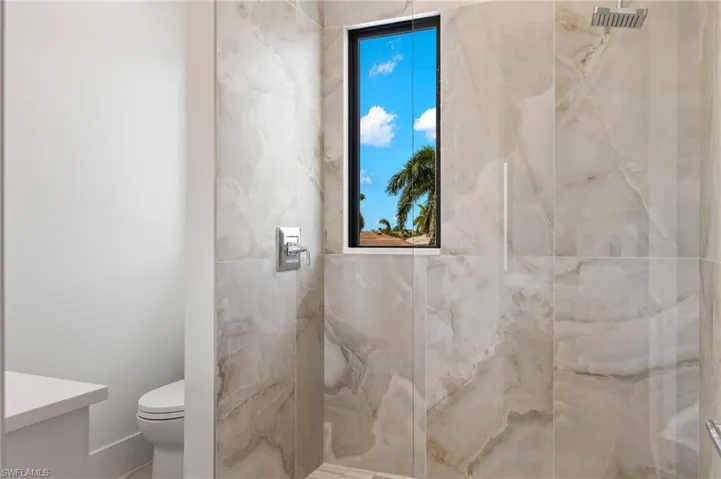 Bathroom with a marble finish shower and vanity