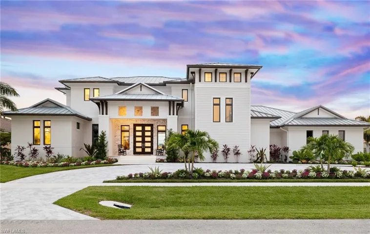 View of front facade featuring french doors, a standing seam roof, a metal roof, and a lawn