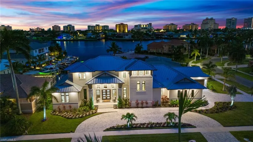 View of front of property with french doors, decorative driveway, a skyline view, a metal roof, and a standing seam roof