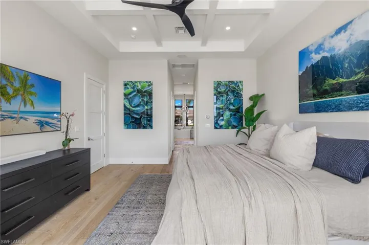 Bedroom with coffered ceiling, light wood-style flooring, beam ceiling, ceiling fan, and recessed lighting