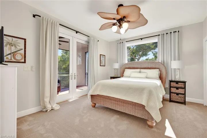 Carpeted bedroom featuring french doors, access to outside, and a ceiling fan