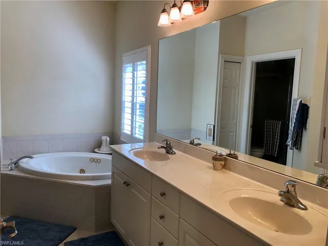 Full bathroom featuring double vanity and a whirlpool tub