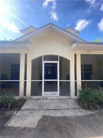 Doorway to property featuring stucco siding