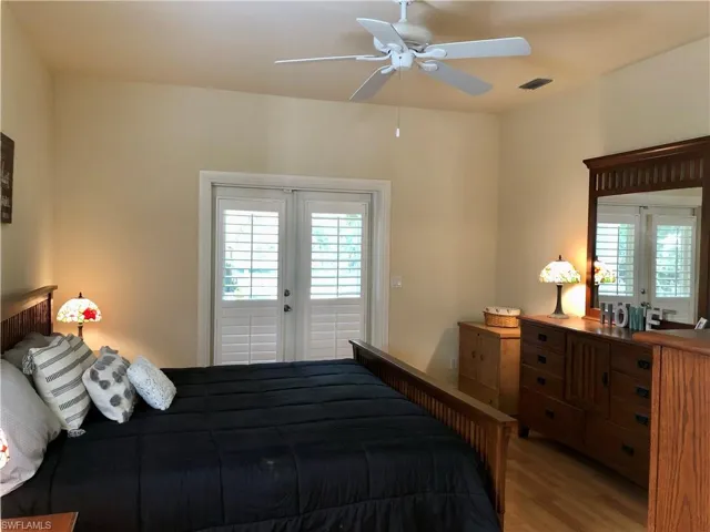 Bedroom featuring french doors, access to outside, wood finished floors, and a ceiling fan