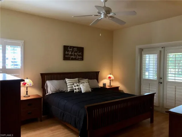 Bedroom with access to outside, wood finished floors, french doors, and ceiling fan