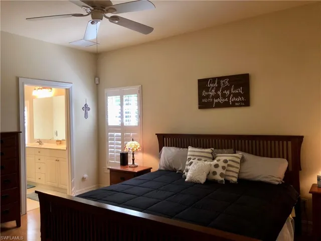 Bedroom with ensuite bath and wood finished floors