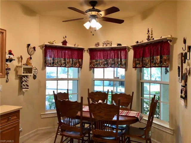 Dining room with a ceiling fan and light tile patterned flooring