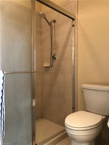 Full bathroom with a stall shower and toilet