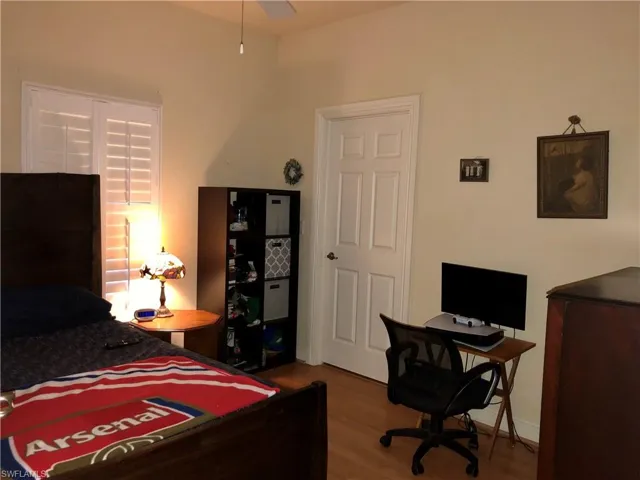 Bedroom featuring dark wood-style floors and an office area