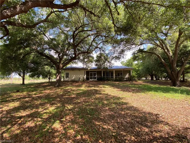 Ranch-style house featuring a front lawn and a sunroom