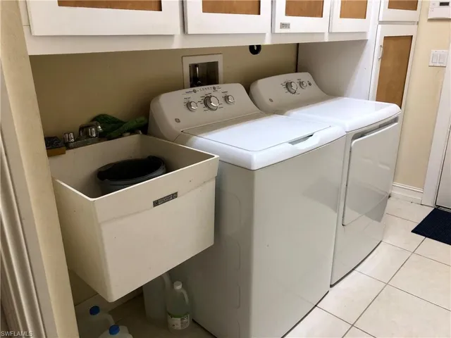 Laundry room featuring light tile patterned floors and washer and dryer
