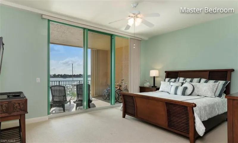 Bedroom with baseboards, a ceiling fan, access to outside l, a wall of windows, and carpet floors