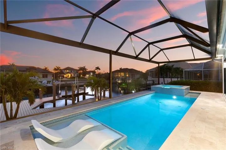 View of swimming pool with a dock, a pool with connected hot tub, a patio, and a lanai