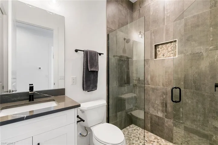 Full bathroom with a stall shower, vanity, and toilet