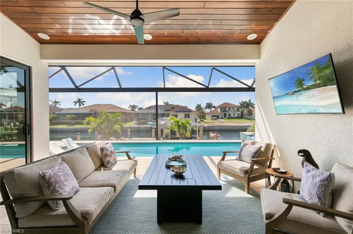 Sunroom / solarium featuring wooden ceiling, ceiling fan, a residential view, and a pool