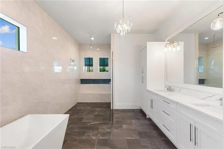 Bathroom with a wealth of natural light, a freestanding bath, a sink, and tiled shower