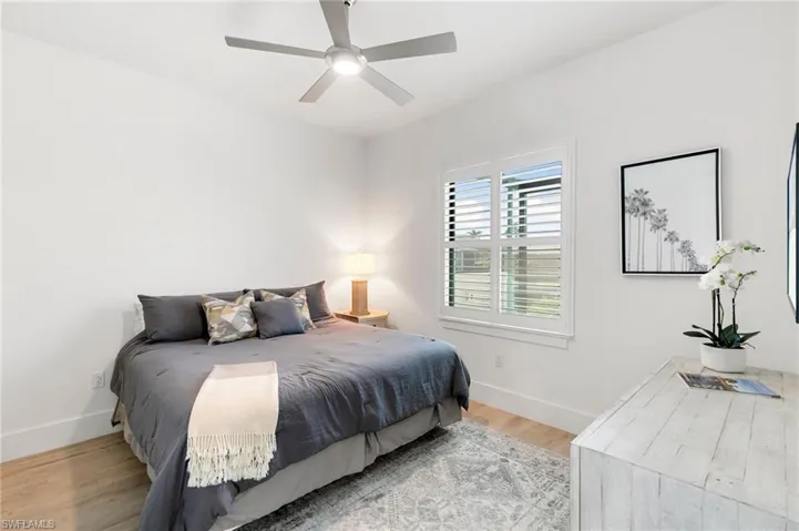 Bedroom featuring ceiling fan, baseboards, and wood finished floors