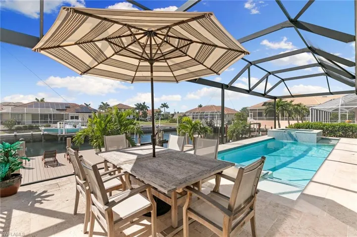 View of swimming pool featuring outdoor dining space, a lanai, a patio, and a pool with connected hot tub