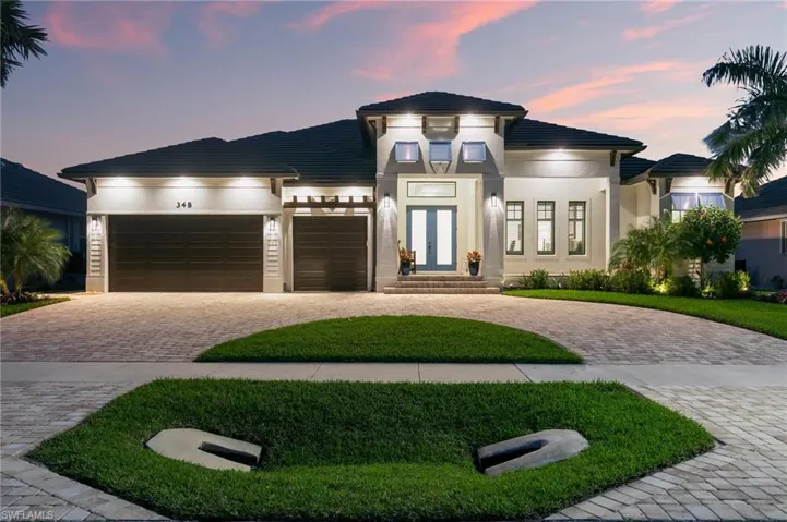 Prairie-style house featuring a garage, french doors, decorative driveway, and stucco siding