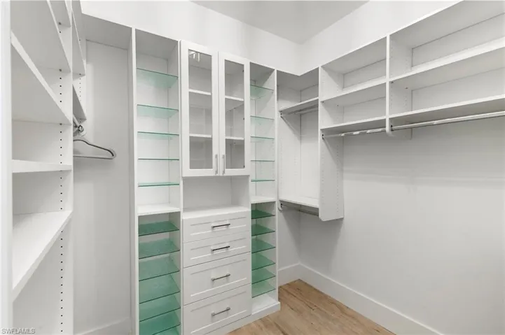 Walk in closet with light wood-style floors