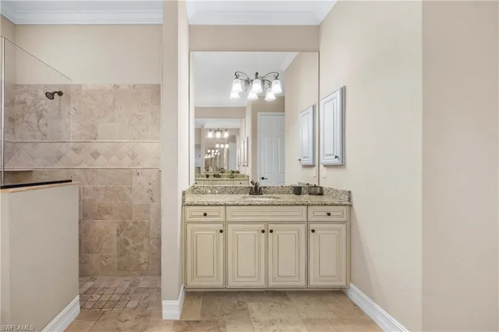 Full bath with vanity, ornamental molding, and walk in shower