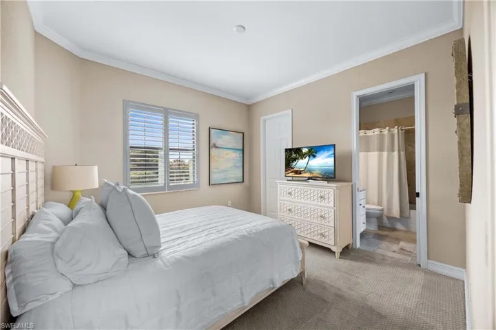 Carpeted bedroom with crown molding