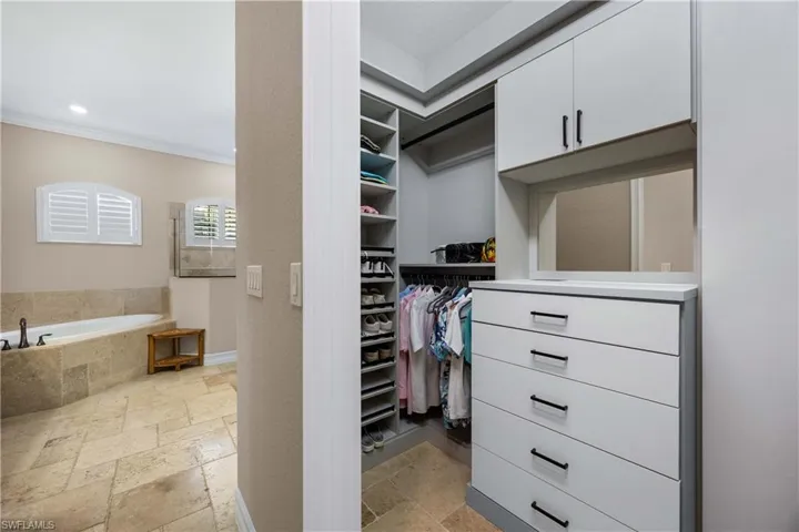 Spacious closet featuring stone tile floors