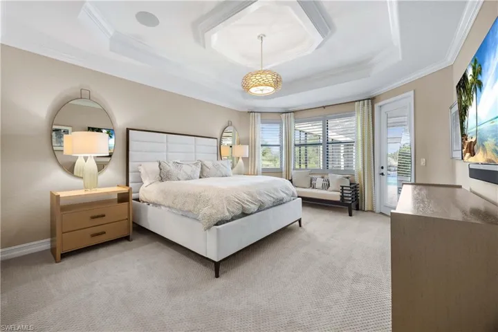 Bedroom with access to exterior, carpet, crown molding, and a raised ceiling