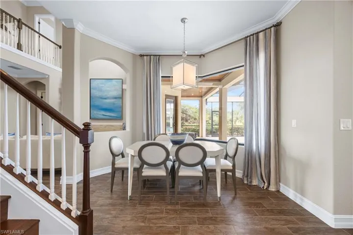 Dining room with ornamental molding, wood finish floors, and stairs