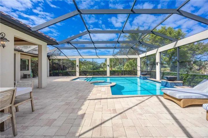 View of swimming pool with glass enclosure, a patio area, a sunroom, and a pool with connected hot tub