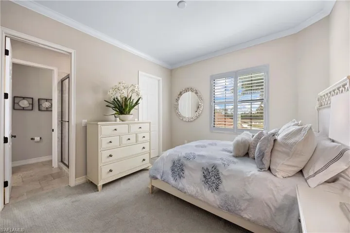 Bedroom featuring light carpet and crown molding