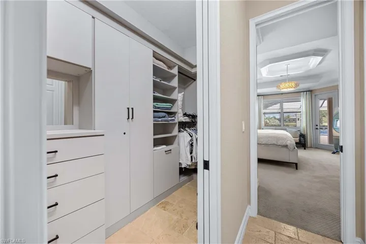 Spacious closet with stone tile flooring and light colored carpet