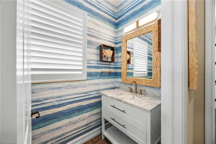 Bathroom with vanity and wallpapered walls