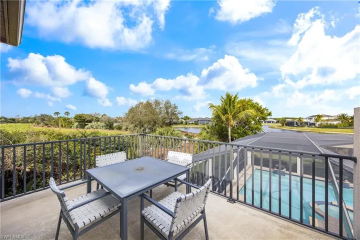 Balcony with outdoor dining area, view of pool area, and a water view