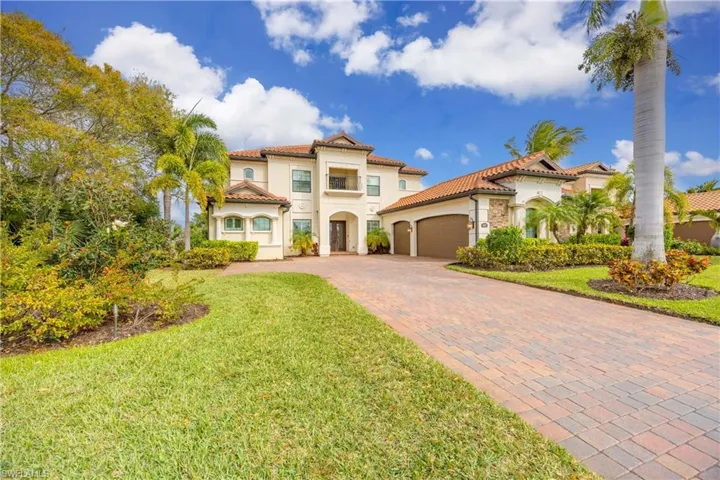 Mediterranean / spanish-style house featuring stucco siding, decorative driveway, an attached garage, a tile roof, and a front lawn