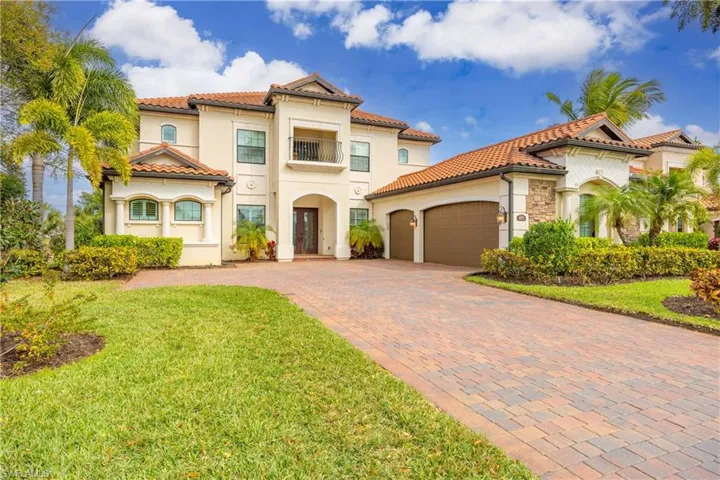 Mediterranean / spanish home with a balcony, stucco siding, a garage, decorative driveway, and a front lawn