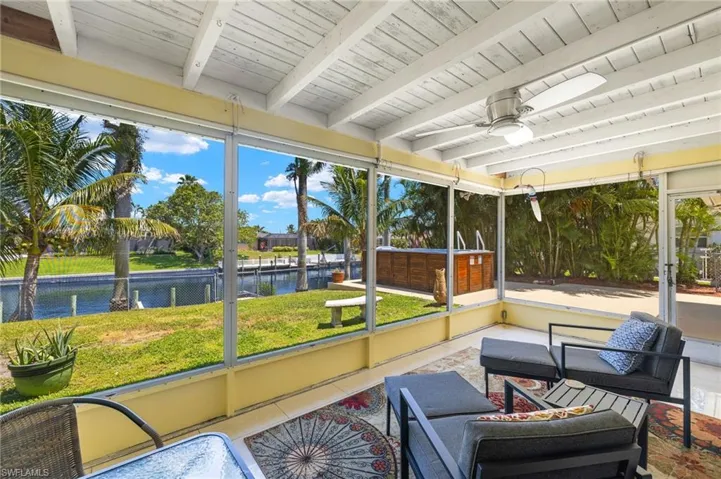 Sunroom / solarium with a healthy amount of sunlight, ceiling fan, and a water view