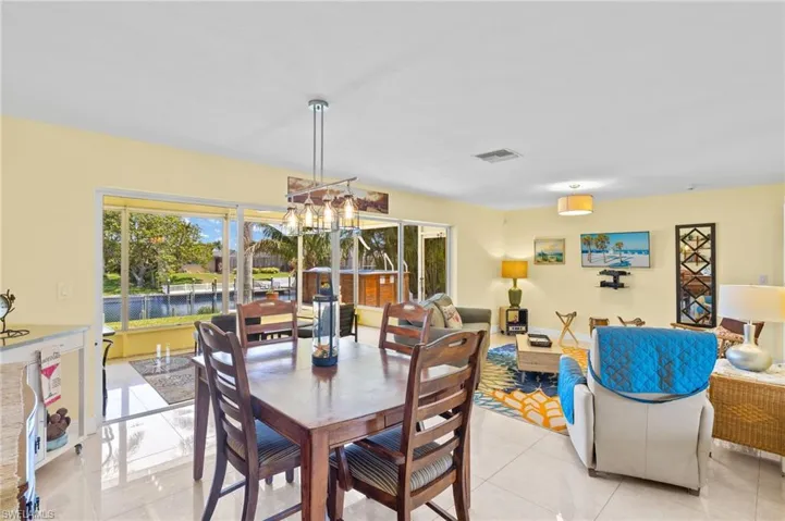 Dining space featuring light tile patterned flooring, visible vents, and a chandelier