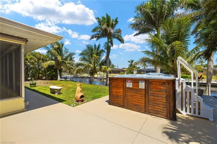 View of patio featuring a water view and a hot tub