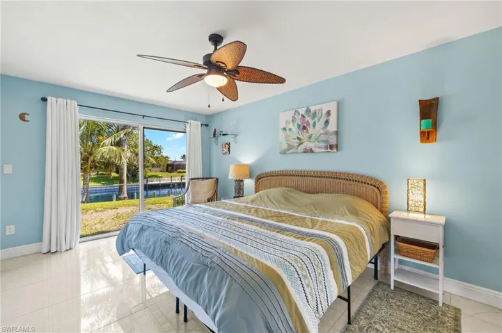 Bedroom with a ceiling fan, access to exterior, and baseboards