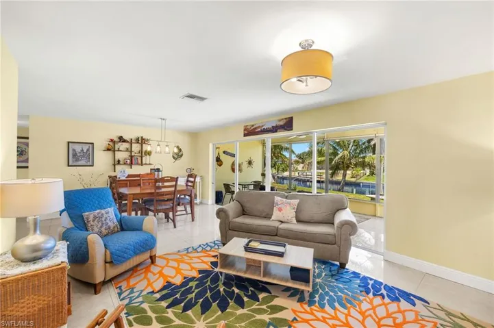 Living room featuring tile patterned floors, visible vents, a chandelier, and baseboards