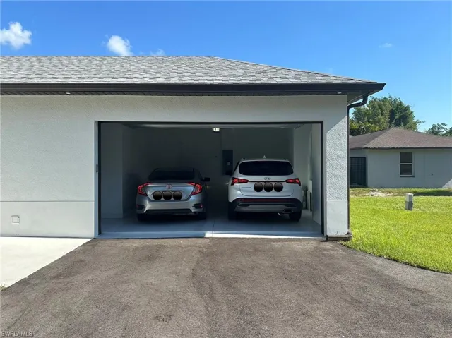 Garage with a lawn and a carport