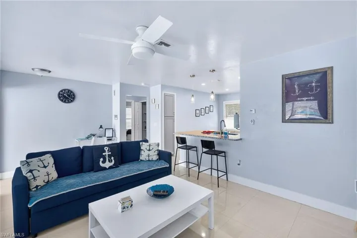 Living room with ceiling fan and light tile patterned floors