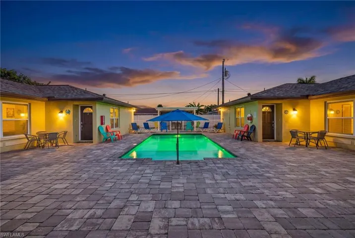 Pool at dusk featuring a patio area and outdoor dining area