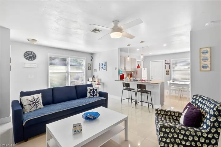 Living area featuring a ceiling fan and light tile patterned floors