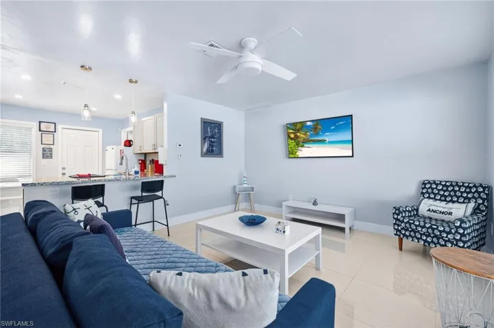 Living room with light tile patterned floors, a ceiling fan, and recessed lighting